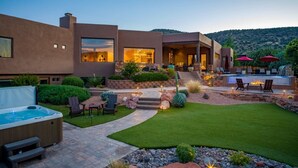 Una casa moderna con patio, bañera de hidromasaje y zona de estar al aire libre.