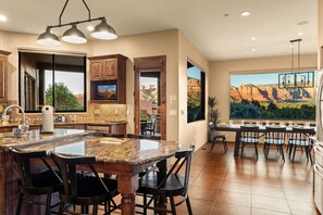 A spacious kitchen with a large island, dining area, and a scenic view. - 5.5k Sqft Luxury Home with Large Suites, Views, Hot Tub & Firepit (Sedona)