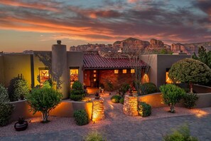 A building with a tiled roof, surrounded by landscaped gardens and a view of a mountainous landscape. - 5.5k Sqft Luxury Home with Large Suites, Views, Hot Tub & Firepit (Sedona)