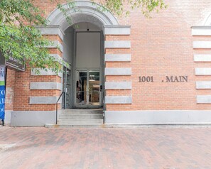 A brick building with a glass entrance and a sign reading "1001 MAIN". - Walkable Downtown King w/ Desk, Washer/Dryer & Gym (Richmond)