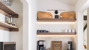 A modern kitchen with wooden cabinetry, a built-in microwave, and a coffee maker. - Hillside Haven | Wellness Spa, Pickleball, Games (Sedona)