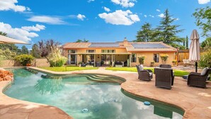 Ein Haus mit Swimmingpool, Gartenmöbeln und einer Terrasse.