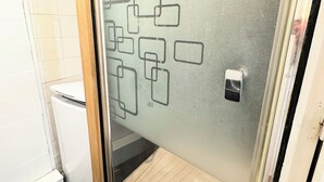Ein Badezimmer mit Glasduschtür, Toilette und Duschbereich.