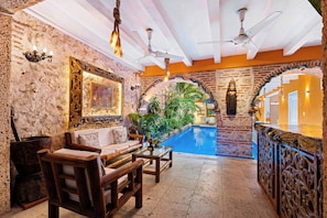 A room with a pool, wooden furniture, and decorative arches. - 15BR Mansion in the Walled City / Staff Included (Cartagena de Indias)