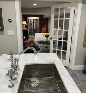 A bathroom with a marble sink, a glass shower enclosure, and a visible showerhead. - FIFA World Cup 1-Bedroom Apartment in Buckhead, Atlanta, Georgia (Atlanta)