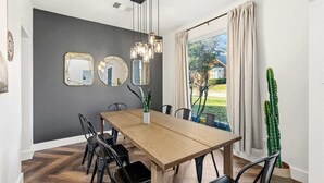 A dining area with a wooden table, black chairs, and a cactus plant. - 5-BD Getaway w/ Pool, Patio, Firepit | Mins to DT (Dallas)