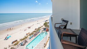 Un balcón con vistas a la playa y al área de la piscina.