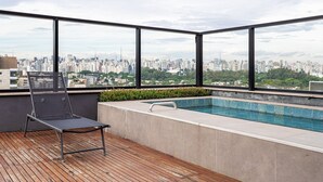 A rooftop terrace with a pool, a lounge chair, and a city view. - Pivô Vila Nova by Viva - Conforto e Localização Privilegiada (São Paulo)