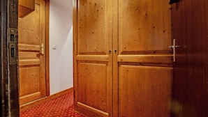 A hallway with wooden double doors, a red patterned carpet, and a light fixture on the ceiling. - Mountain-View with Ski-In ski Out Stay (Val Thorens)