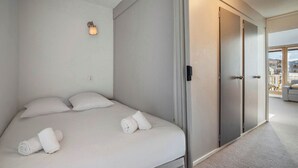 Ein modernes Hotelzimmer mit einem Bett, einer Wandleuchte und einer Schiebetür.