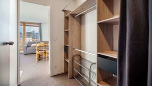 Ein begehbarer Kleiderschrank mit offenen Regalen und einem Metallgestell.