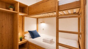 A bunk bed room with wooden walls and a small shelf with a plant. - Sunny Ski-In/Out Mountain Views (Val Thorens)