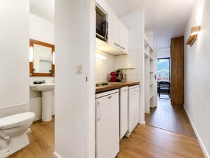 A compact kitchen with a sink, countertop, and a coffee machine. - Sunny Ski-In/Out Mountain Views (Val Thorens)