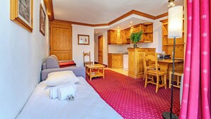 A compact room with a bed, a desk, and a kitchenette. - Slope-Side Apt w/Balcony & Views (Val Thorens)