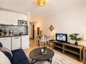 Ein kompakter Wohnbereich mit einer Küche, einem Essbereich und einer Sitzecke mit Fernseher.