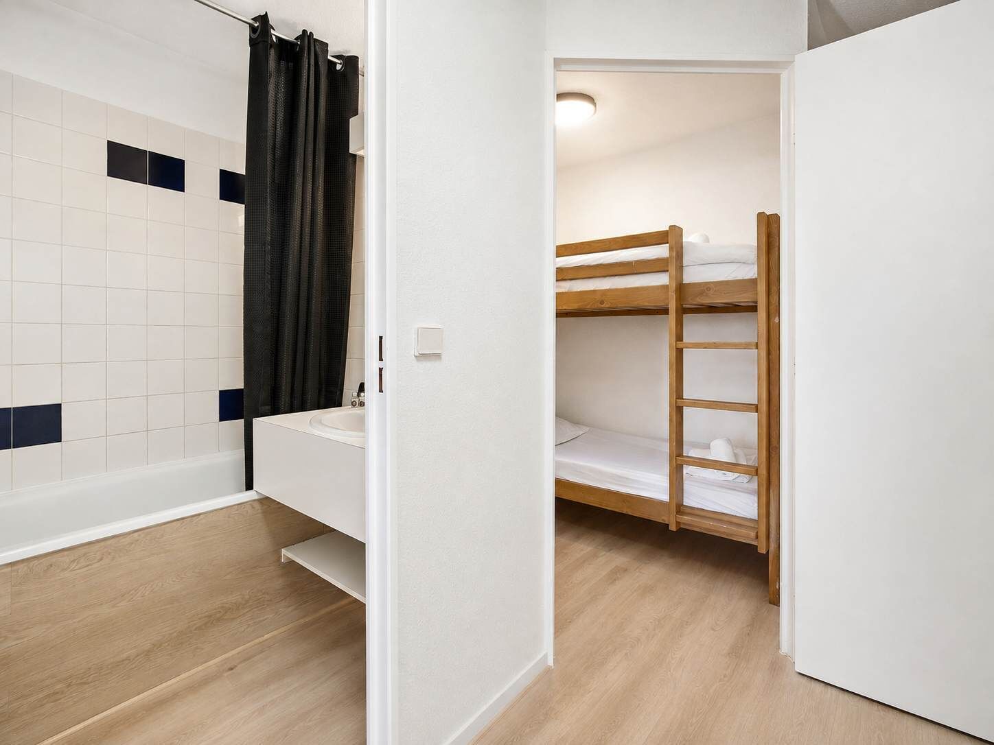 Une salle de bain avec une baignoire, un lavabo et un rideau de douche.