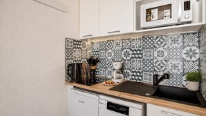 Cocina compacta con microondas, cafetera y lavavajillas.