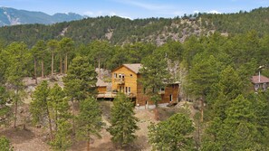 A two-story wooden cabin surrounded by dense forest, with a clear view of the mountains in the background. - Private Bailey Mountain Retreat w/ Views (Bailey)