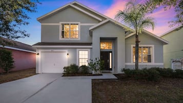 A two-story house with a garage, a front door, and a driveway.