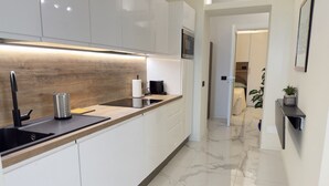 Een moderne keuken met een houten aanrecht, een spoelbak en een ingebouwde oven.