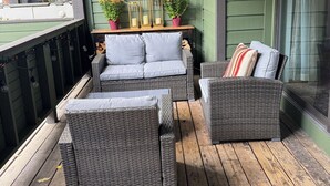 A covered porch with wicker furniture, a table with decorative items, and a view of the outdoors. - Serene 2-bedroom condo in Eagle-Vail, perfect for a fun getaway (Avon)