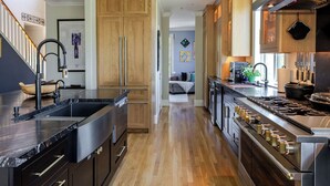 A modern kitchen with wooden cabinets, stainless steel appliances, and a central island. - The Napa Sanctuary • Vineyard Views • Hot Tub (Napa)