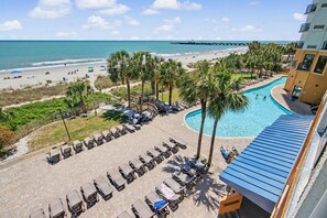 Un complexe hôtelier doté d’une piscine, d’une plage et offrant une vue sur l’océan.