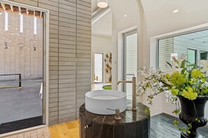 A modern bathroom with a large mirror, a round sink, and a potted plant. - Designer Mansion - Indoor Pickleball & Sleeps 20+ (Phoenix)
