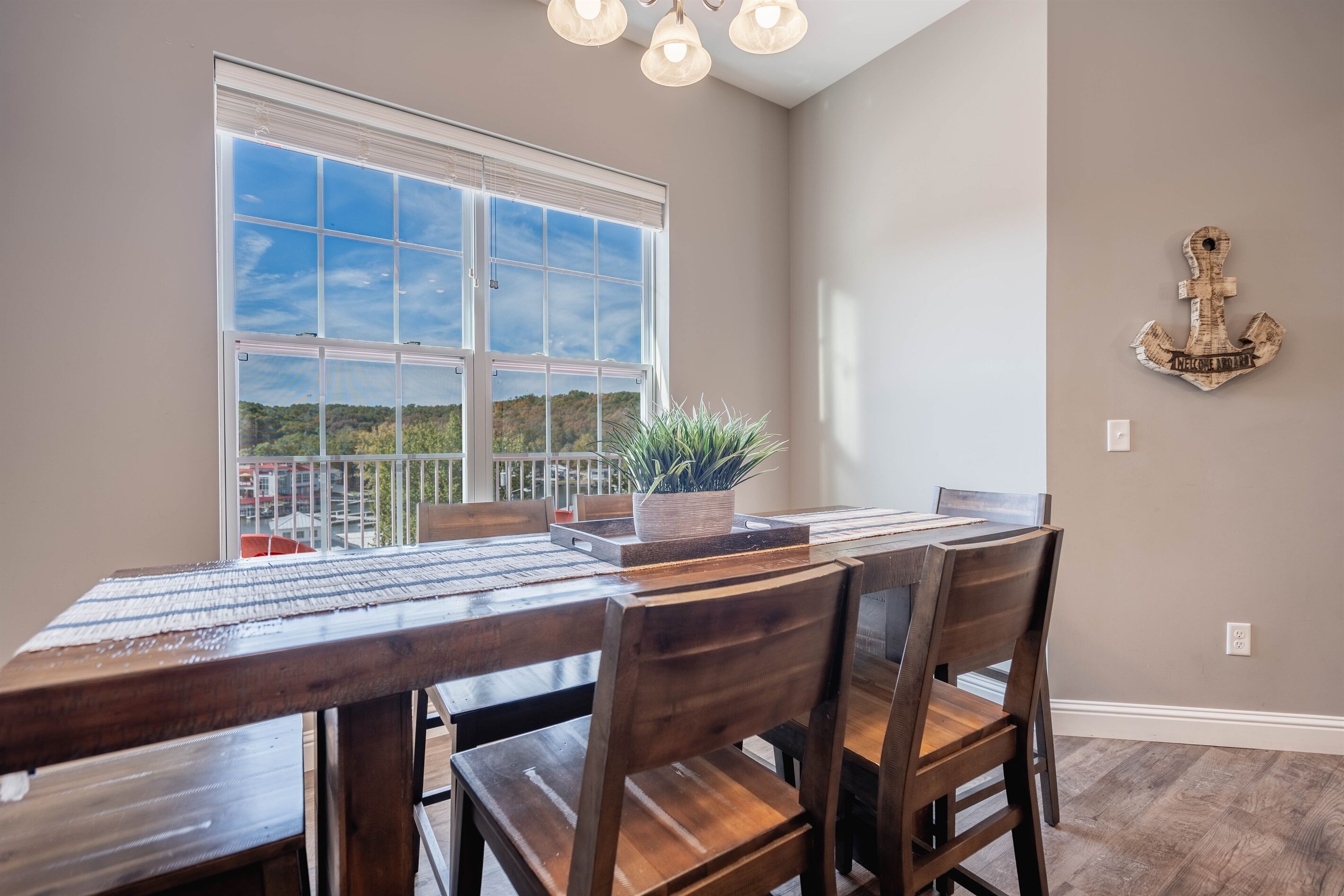 A dining area with a large window, wooden table, and chairs.