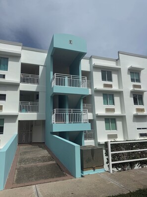 A multi-story residential building with a light blue facade, white balconies, and a central entrance. - Penthouse with Pool Near El Yunque & Luquillo Beaches (Río Grande)