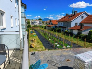 A residential area with houses, a garden, and a clear sky. - 1OG R City Wohnung Balkon nähe Salzburg (Freilassing)