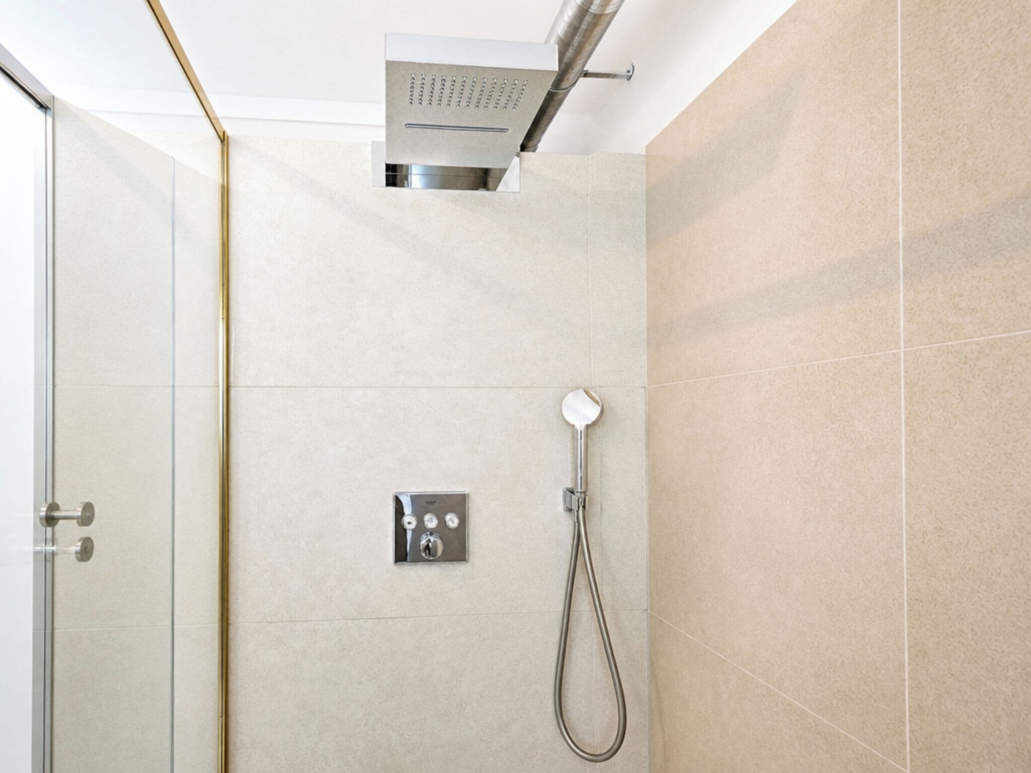 Ein modernes Duschbad mit Handbrause und Bedienfeld.
