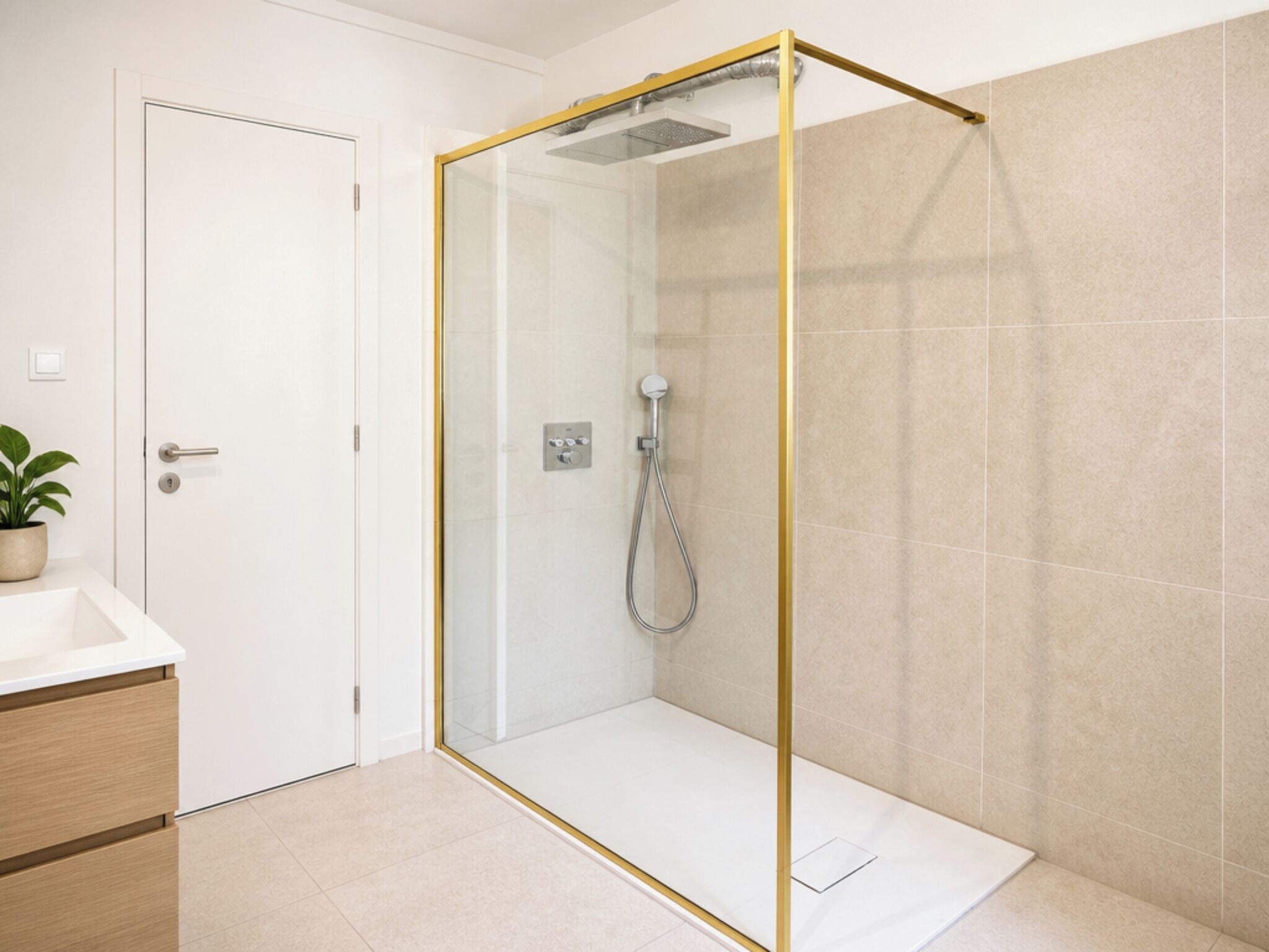 Un bagno moderno con doccia vetrata, una porta bianca e una pianta in vaso sul ripiano.