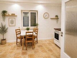 Una cocina con una mesa de comedor, sillas, un reloj y una estufa.