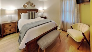 A neatly arranged bedroom with a bed, bedside tables, a chair, and a television. - Casa Cielo (Santa Fe)