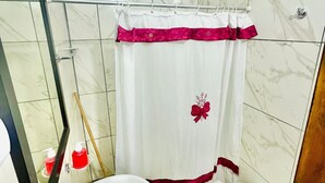 Une salle de bain avec un rideau de douche, deux lavabos et un miroir.