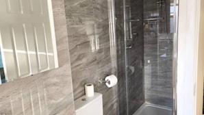 A modern bathroom with a glass-enclosed shower, a toilet, and a sink. - West Midlands Home - 3BR w/FREE Parking and WIFI (West Midlands)