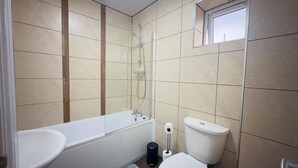 Un bagno con vasca, servizi igienici e una finestra.