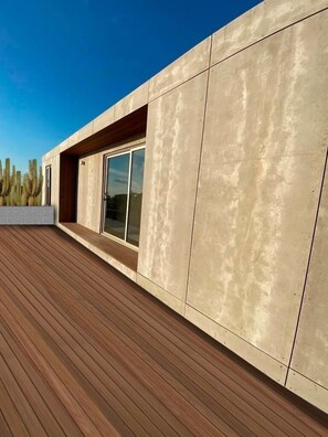 A modern building with a wooden deck and a large glass window.