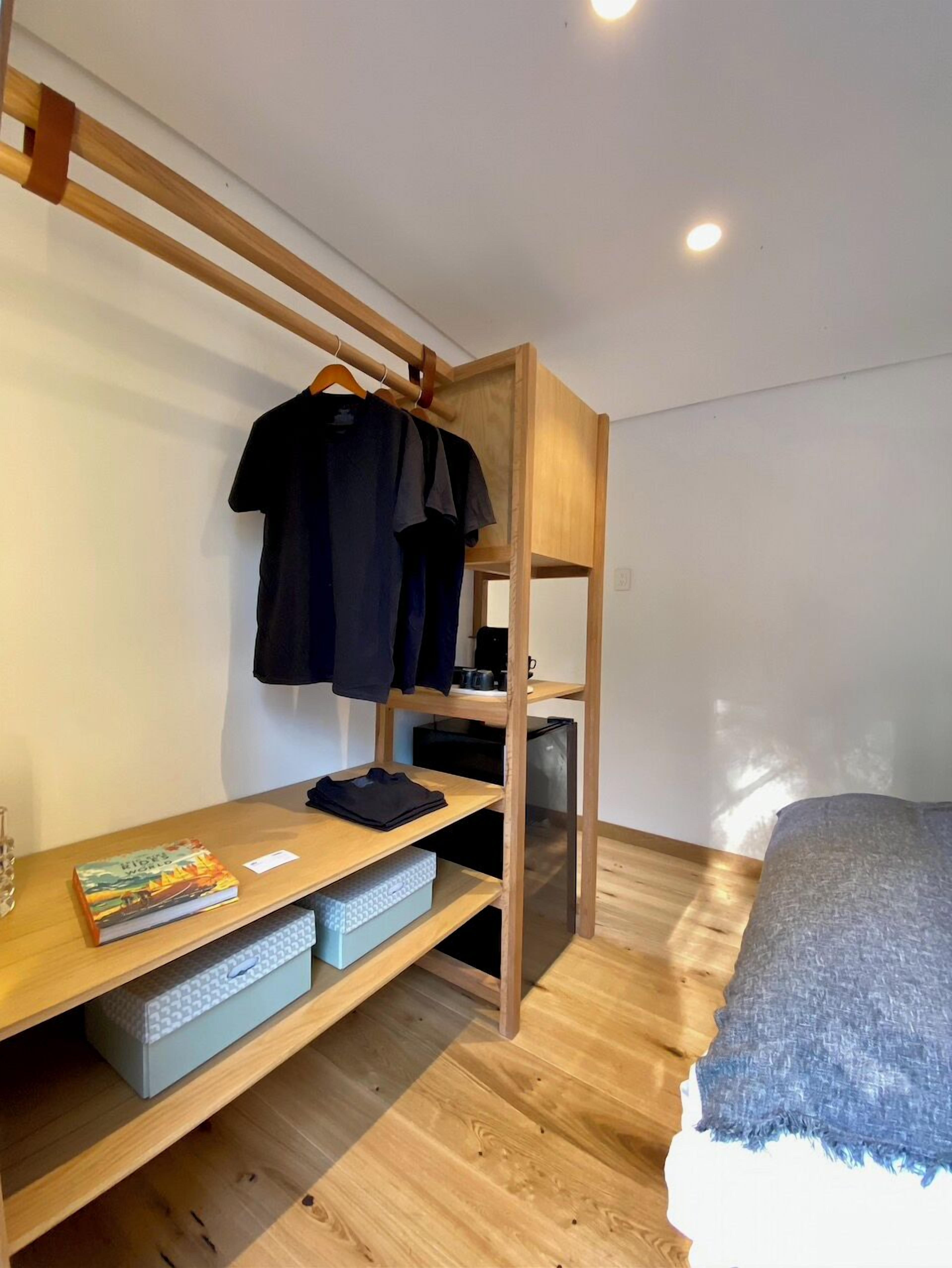 A bunk bed with a desk and shelves, a book, and a blanket on the bed.
