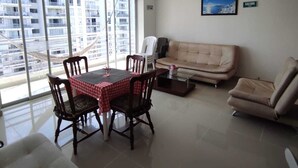 A modern living room with a dining table, chairs, a sofa, and a coffee table.