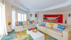 Ein modernes Wohnzimmer mit zwei Sofas, einem Couchtisch und einem farbenfrohen Teppich.