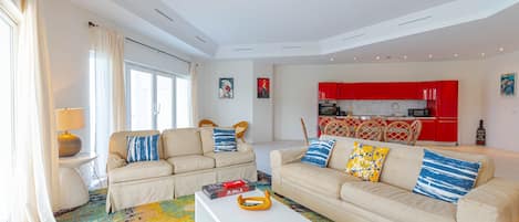 A modern living room with two sofas, a coffee table, and a colorful rug.