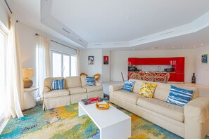 Ein modernes Wohnzimmer mit zwei Sofas, einem Couchtisch und einem farbenfrohen Teppich.