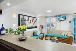 A modern living room with a sofa, a coffee table, and a TV. - Casa Nueve -Charming 9BR House w/ Pool on Rooftop in the Old City (Cartagena de Indias)