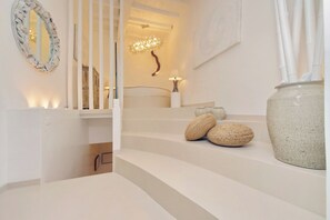 A staircase with a white railing, a wall-mounted mirror, a decorative light fixture, and a large vase. - PIAZZA NAVONA WELLNESS LUXURY APARTMENT 8 PEOPLE (Roma)