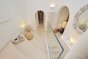 A modern interior with a glass railing, white walls, and a central hallway leading to a door. - PIAZZA NAVONA WELLNESS LUXURY APARTMENT 8 PEOPLE (Roma)