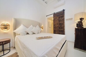 A bedroom with a large bed, a bedside table, a lamp, and a wooden wardrobe. - PIAZZA NAVONA WELLNESS LUXURY APARTMENT 8 PEOPLE (Roma)