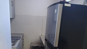 A compact kitchen with a refrigerator, stove, and cabinets. - Wonderful 1-bedroom apartment with AC in welcoming Noord (Noord)