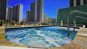Una piscina en la azotea con vista a edificios altos.